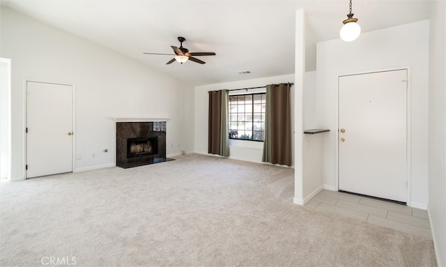 foyer featuring lofted ceiling, ceiling fan, a high end fireplace, and light colored carpet