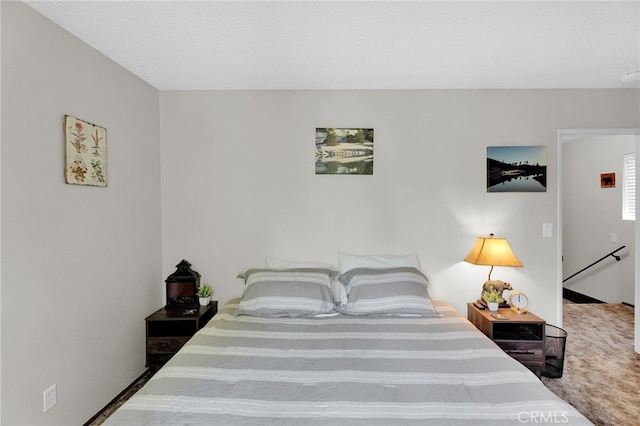 bedroom featuring a textured ceiling and carpet