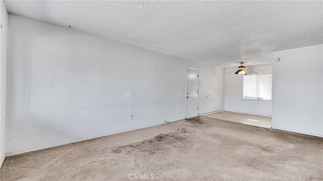 unfurnished room featuring a textured ceiling, light colored carpet, and ceiling fan