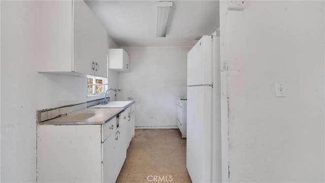 kitchen with white cabinets, washer / dryer, white fridge, and sink