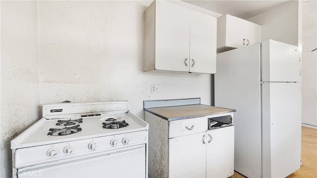 kitchen with white appliances and white cabinetry