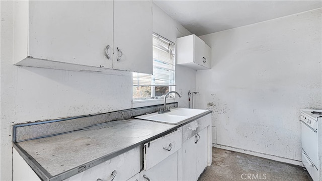 kitchen with concrete flooring, sink, and white cabinetry