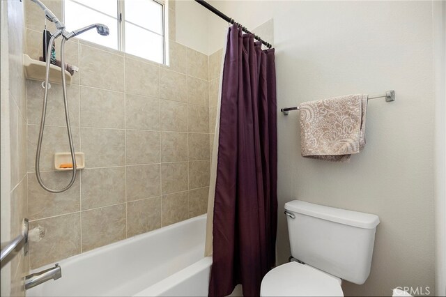 bathroom with shower / bath combination with curtain and toilet