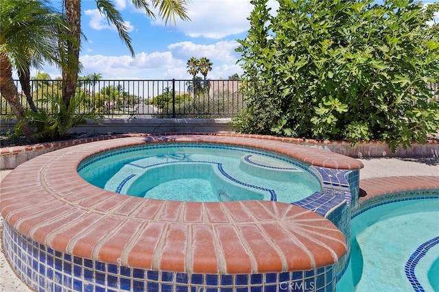 view of swimming pool featuring an in ground hot tub