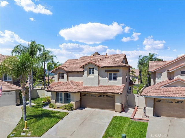 mediterranean / spanish house with a garage and a front lawn