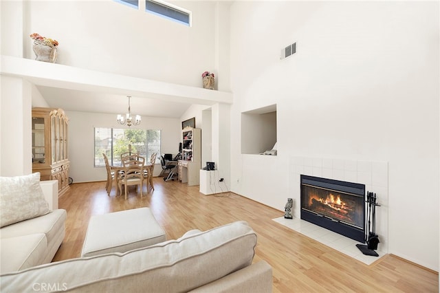 living room with a notable chandelier, hardwood / wood-style floors, and a fireplace