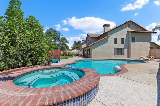 view of pool with a patio and an in ground hot tub