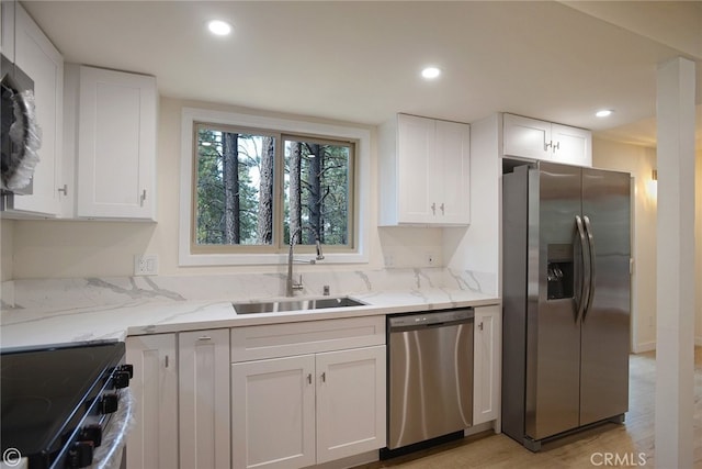 kitchen featuring stainless steel appliances, recessed lighting, white cabinetry, and a sink