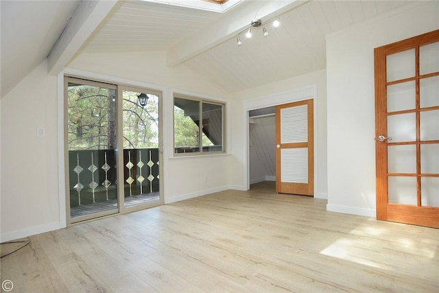 unfurnished room with lofted ceiling with beams, baseboards, and wood finished floors