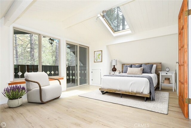 bedroom with access to exterior, light hardwood / wood-style floors, and vaulted ceiling with skylight