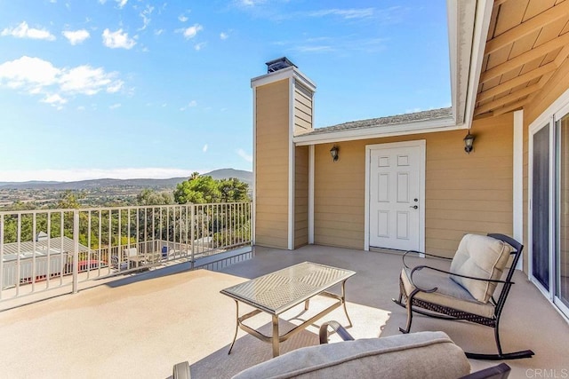 view of patio featuring a mountain view and a balcony