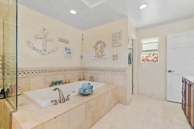 bathroom with vanity, a relaxing tiled tub, and tile patterned floors