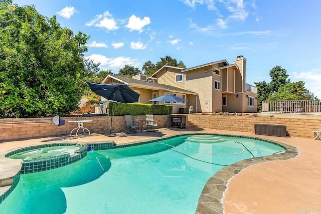 view of swimming pool with an in ground hot tub and a patio