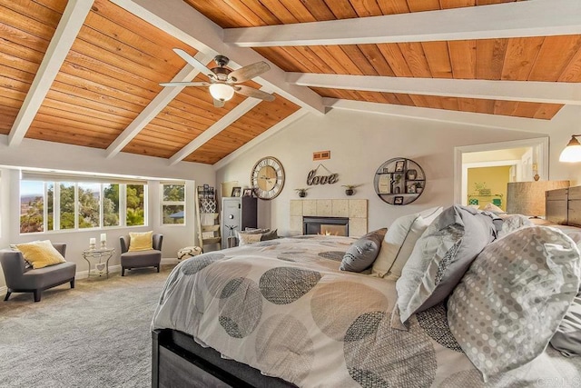 bedroom with carpet flooring, lofted ceiling with beams, wood ceiling, and a tiled fireplace