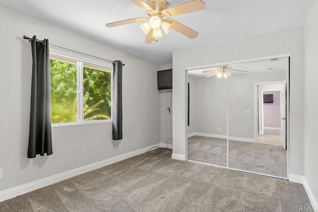 unfurnished bedroom with carpet flooring, ceiling fan, and a closet