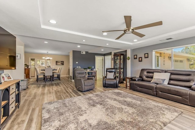 living room with light hardwood / wood-style flooring, plenty of natural light, and ceiling fan