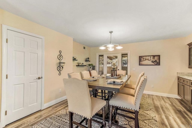 dining room featuring light hardwood / wood-style flooring and a chandelier