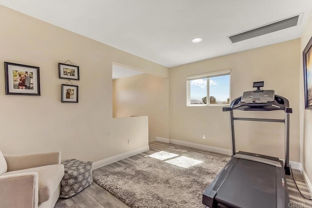 exercise room with light hardwood / wood-style floors