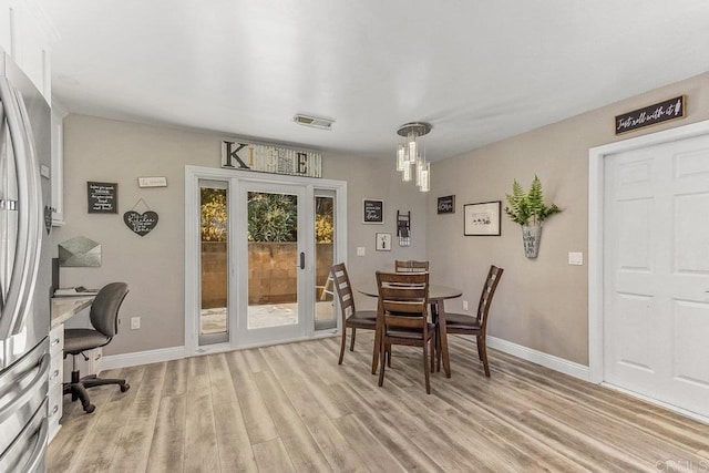 dining space featuring light wood-type flooring and french doors