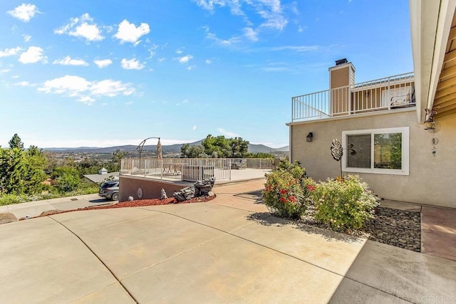 view of patio with a mountain view and a balcony