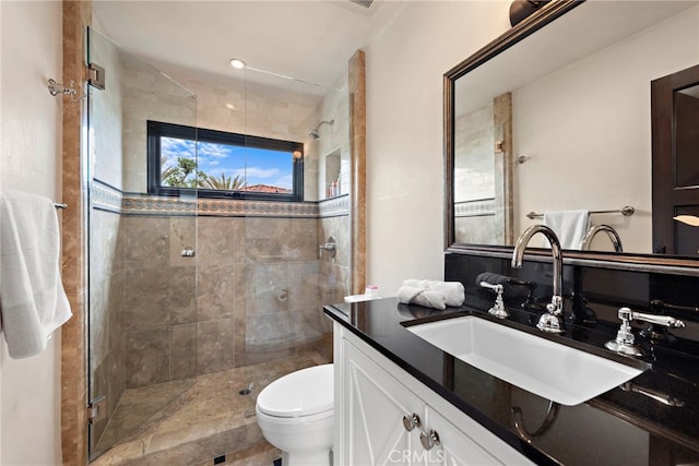 bathroom with an enclosed shower, vanity, and toilet