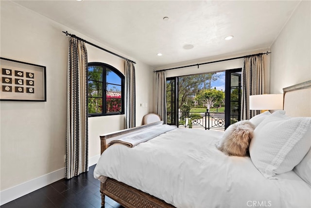 bedroom with dark wood-type flooring, access to exterior, and multiple windows