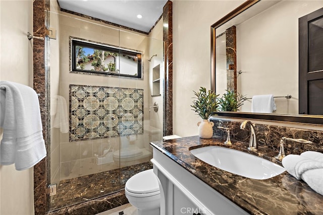 bathroom featuring an enclosed shower, vanity, and toilet