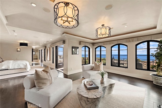 bedroom featuring a water view, multiple windows, a chandelier, and dark hardwood / wood-style floors