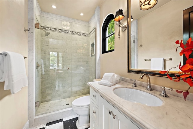 bathroom with a shower with door, vanity, and toilet