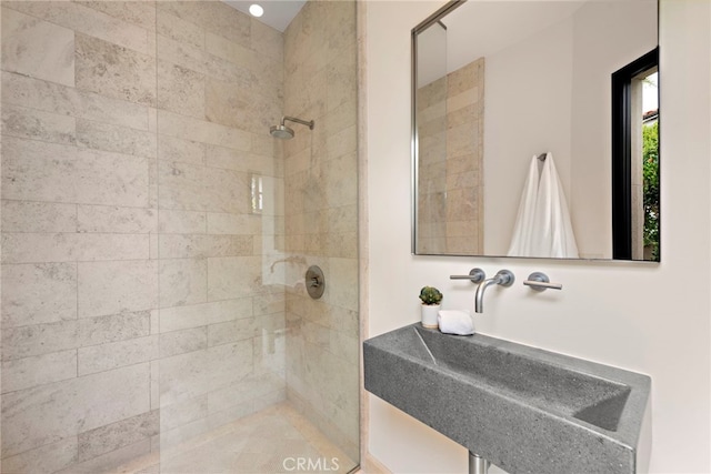 bathroom featuring sink and a tile shower