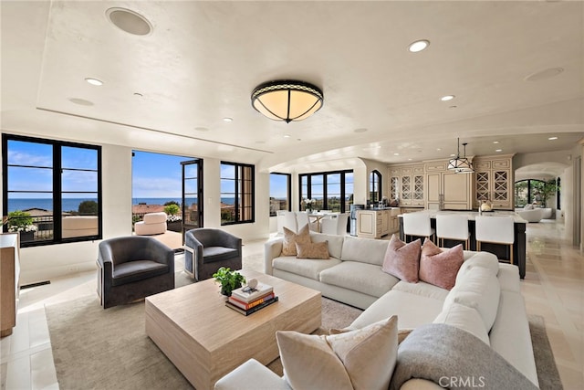 tiled living room featuring a water view