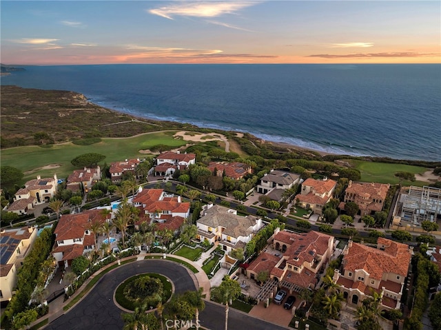 aerial view at dusk featuring a water view