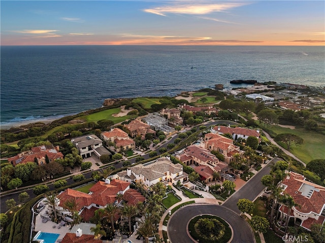 aerial view at dusk featuring a water view