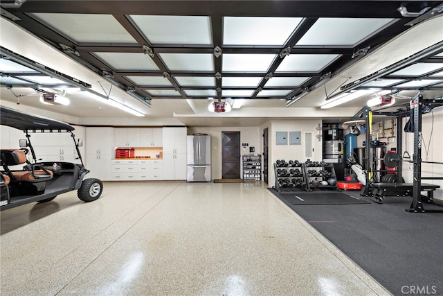 garage with a garage door opener and stainless steel fridge