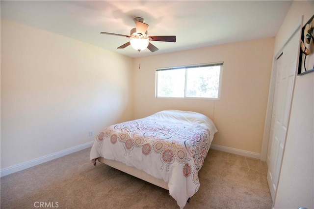 carpeted bedroom with ceiling fan and a closet