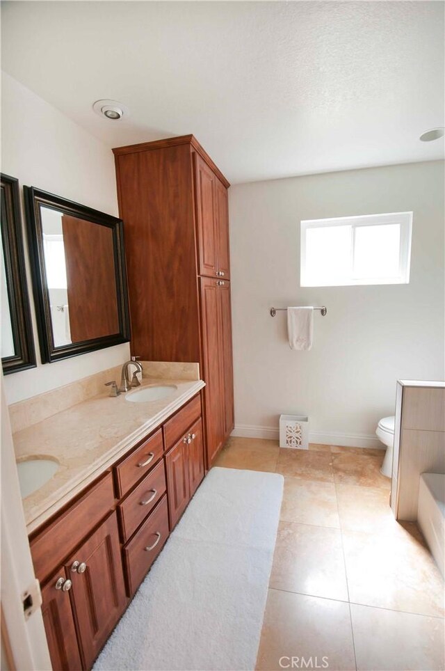 bathroom with tile patterned flooring, vanity, and toilet