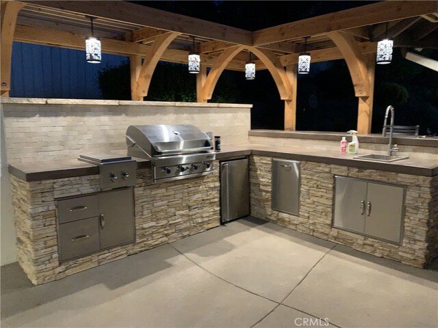 view of patio / terrace with area for grilling, a grill, and sink