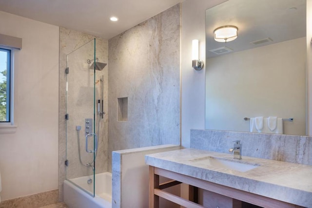 bathroom with combined bath / shower with glass door and vanity