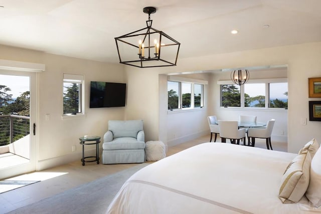 bedroom featuring access to exterior, light hardwood / wood-style flooring, and an inviting chandelier