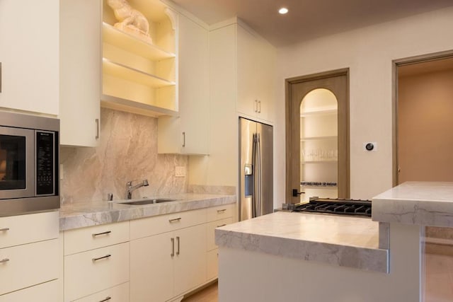 kitchen with white cabinets, decorative backsplash, sink, and stainless steel appliances