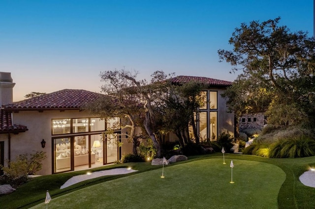 view of back house at dusk