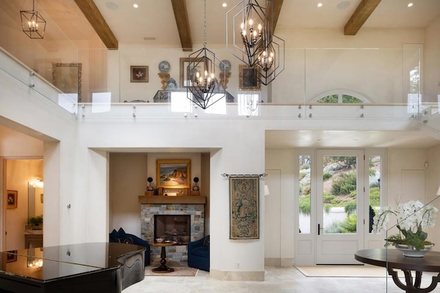 interior space featuring beam ceiling, a fireplace, a wealth of natural light, and a towering ceiling