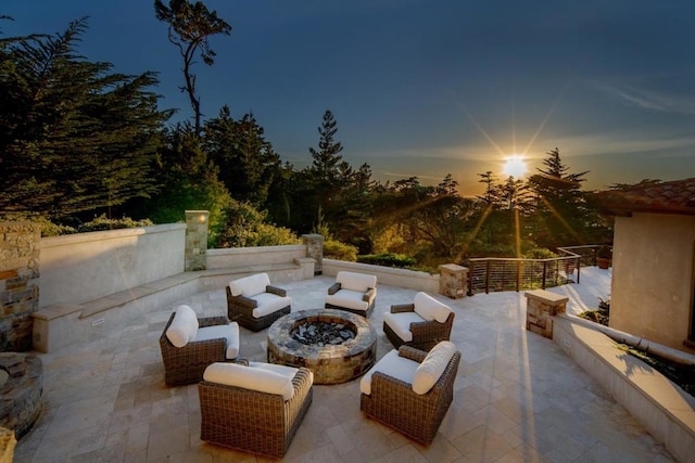 patio terrace at dusk featuring an outdoor living space with a fire pit