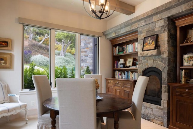 dining room featuring a notable chandelier, beam ceiling, and a stone fireplace