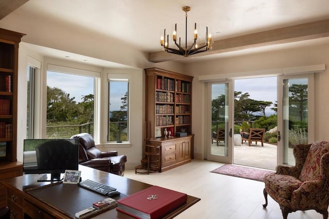 home office featuring french doors, plenty of natural light, an inviting chandelier, and light hardwood / wood-style flooring