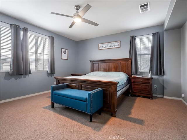 bedroom with ceiling fan, multiple windows, and dark colored carpet