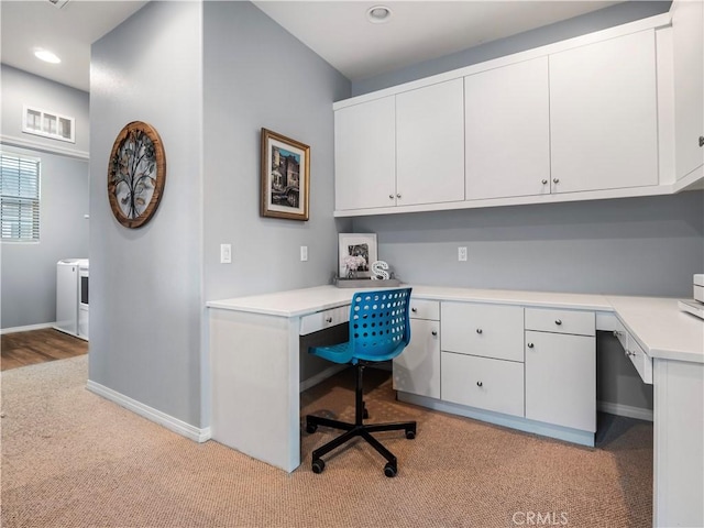 carpeted home office with built in desk