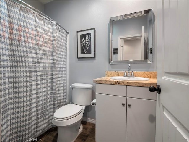 bathroom with toilet, vanity, and hardwood / wood-style floors