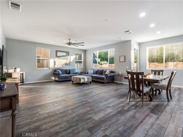 dining space with ceiling fan and dark wood-type flooring