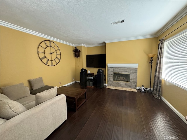 living room with a textured ceiling, a stone fireplace, ornamental molding, and dark hardwood / wood-style floors